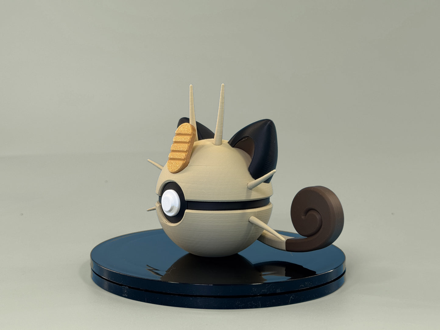 Meowth Inspired Ball — side view showing sphere profile and display stand, cream and brown design