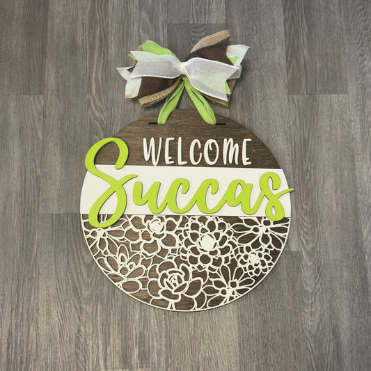 "Welcome Succas" Round Sign